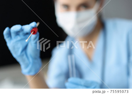 Doctor in medical protective mask holds shelf with test tube for sampling biological material 75595073