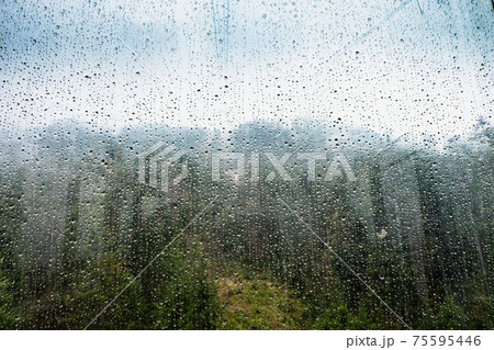 Raindrops on glass window of cableway. Sad view from overhead cable Car Raindrops on glass window of cableway. Sad view from overhead cable Car 75595446
