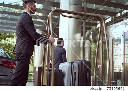 Hotel concierge is responsible for greeting guests and carrying their luggage 75595661