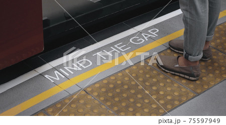 Mind the gap sign. text on train station platform. white text signal on metro or underground floor. Yellow line train station. london england europe old transport platform. Mind the gap for safety. Mind the gap sign. text on train station platform. white text signal on metro or underground floor. Yellow line train station. london england europe old transport platform. Mind the gap for safety. 75597949