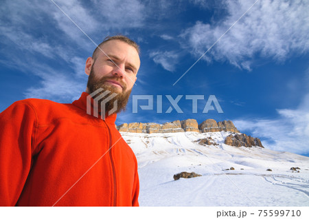 cheerful man with a beard smiles on a background of mountains 75599710
