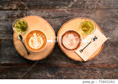 Cup of latte art coffee and chocolate art with hot tea on wooden table, Top view 75603261
