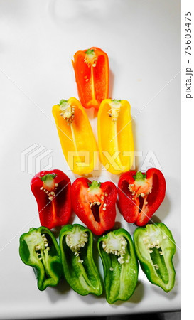 三角形に並べた赤緑黄のカラフルなカットされたパプリカ(縦構図)　4139 75603475