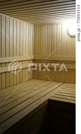 Sauna accessories are in the interior of the steam room. The interior of the sauna. Sauna from linden. 75604314