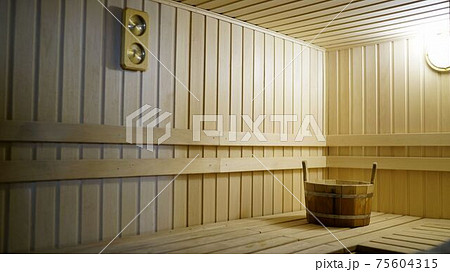 Sauna accessories are in the interior of the steam room. The interior of the sauna. Sauna from linden. Sauna accessories are in the interior of the steam room. The interior of the sauna. Sauna from linden. 75604315