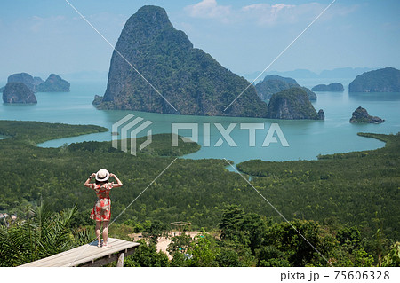 Happy traveler woman enjoy Phang Nga bay view point, alone Tourist standing and relaxing at Samet Nang She, near Phuket in Southern Thailand. Southeast Asia travel, trip and summer vacation concept 75606328