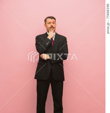 Portrait of young business man standing isolated over pink background. Portrait of young business man standing isolated over pink background. 75606396