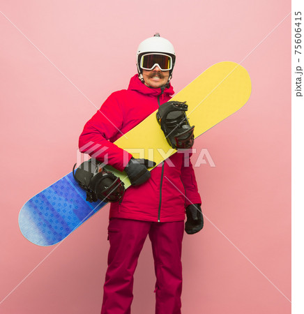 Male snowboarder with skiing gear in bright ski suit isolated on pink background 75606415