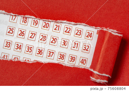 Red paper torn to reveal lottery ticket numbers 75608804