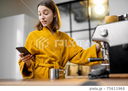 Woman making coffee in the morning at home 75611968