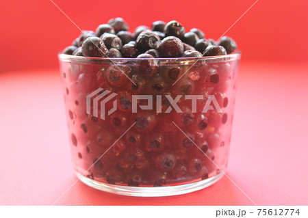 berry still life blueberries or currants in a glass on a red background with a place for text and a copyspace view from the side berry still life blueberries or currants in a glass on a red background with a place for text and a copyspace view from the side 75612774