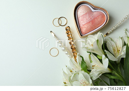 Female concept with jewelry and flowers on white background Female concept with jewelry and flowers on white background 75612827