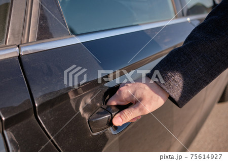 The man closed the back door of the car while going outside. The man closed the back door of the car while going outside. 75614927