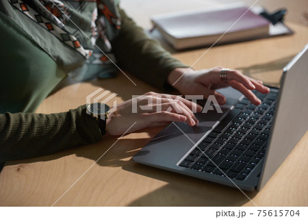 Woman typing on laptop 75615704