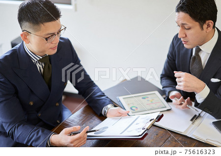 打ち合わせをするアジア人とラテン人のビジネスパーソン 75616323