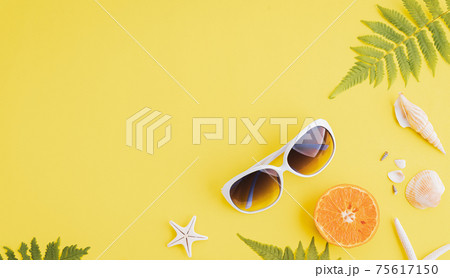 Summer holiday and vacation concept, including beach accessories sunglasses, starfish, orange, fern leaves and sea shell on yellow background. Summer holiday and vacation concept, including beach accessories sunglasses, starfish, orange, fern leaves and sea shell on yellow background. 75617150
