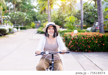 Happy women cycling spreads legs on bicycle at park,Practice pedaling circles,Riding a bike Happy women cycling spreads legs on bicycle at park,Practice pedaling circles,Riding a bike 75618974
