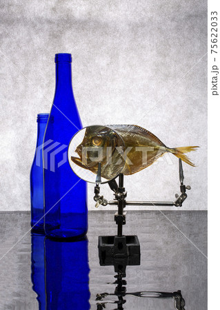 Still life with blue bottles and sea fish with magnifying glass Still life with blue bottles and sea fish with magnifying glass 75622033