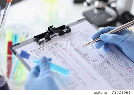 Researcher writes down chemical parameters of liquid in document Researcher writes down chemical parameters of liquid in document 75623961