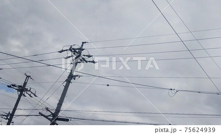 電柱と電線と曇り空 75624939