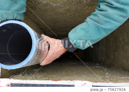 Installation of a ventilation pipe in the chimney, the pipe is wrapped with foil for cooling. 75627926