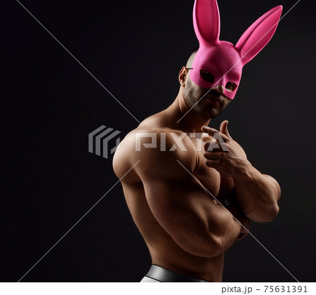 Naked shirtless muscular man wearing pink rabbit Naked shirtless muscular man wearing pink rabbit 75631391