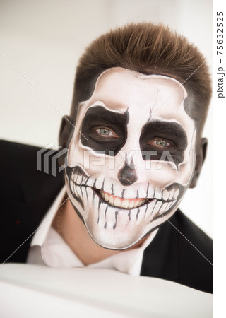 Man with make-up Halloween. Drawing a vampire, skeleton 75632525