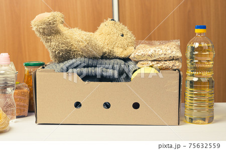 cardboard box with food and things to help those in need, help concept 75632559