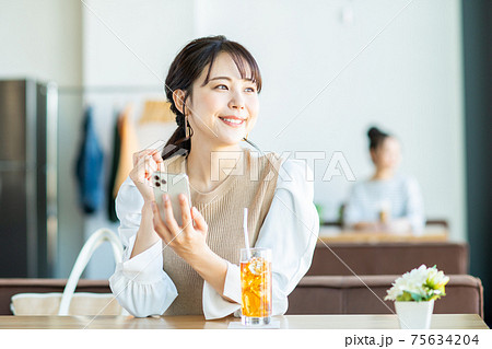 カフェでスマホを見る若い女性 75634204