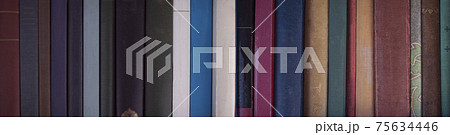 本棚の古い本の背表紙の背景テクスチャー 本棚の古い本の背表紙の背景テクスチャー 75634446