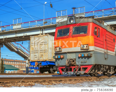 Electric locomotive pulling a cargo train at one of the marshalling yard of Trans-Siberian Railway. 75636690