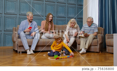 Happy multigenerational family leisure at home couple parents and grandpagents relaxing on sofa Happy multigenerational family leisure at home couple parents and grandpagents relaxing on sofa 75636800