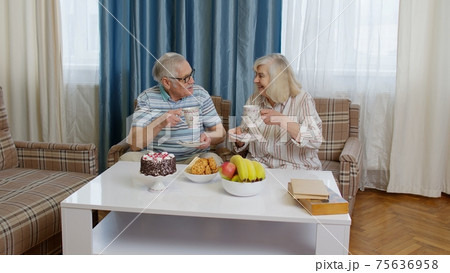 Mature family couple grandfather, grandmother relaxing on cozy sofa enjoying conversation at home Mature family couple grandfather, grandmother relaxing on cozy sofa enjoying conversation at home 75636958
