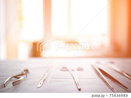 Surgical instruments on the table in the operating room of the hospital. Sunny sunset in the window. Surgery concept, amputation, complications after surgery. Copy space for text Surgical instruments on the table in the operating room of the hospital. Sunny sunset in the window. Surgery concept, amputation, complications after surgery. Copy space for text 75636989