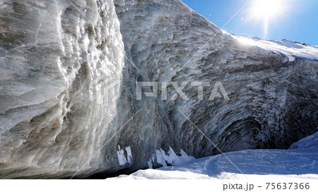 High ice wall in mountains. Bogdanovich Glacier High ice wall in mountains. Bogdanovich Glacier 75637366