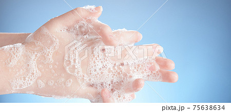 Washing female hands isolated on blue background. 75638634