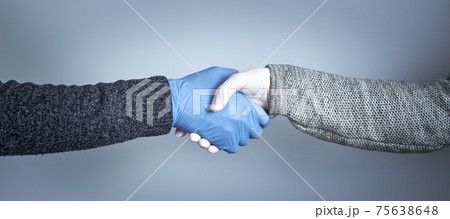 Shaking hands in medical gloves on a gray background. The concept of a safe handshake. 75638648
