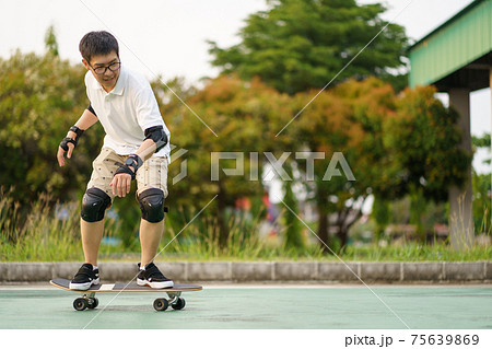 Surfers Asian man having fun with surfboards or surf skate around city streets background on a summer day. Free relax lifestyle and millennial trend concept 75639869