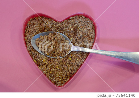 Flax seeds in the shape of a heart on a pink background, top view. Super food. Healthy vegan concept 75641140