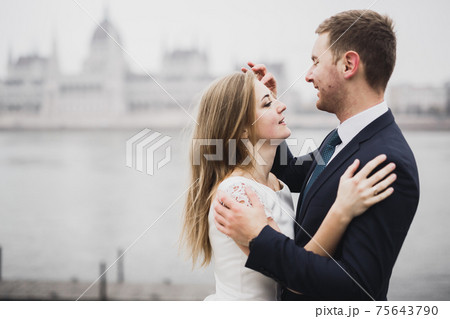 Kissing wedding couple staying over beautiful landscape 75643790