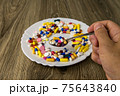 A bunch of pills on a plate 75643840