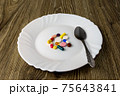 A bunch of pills on a plate 75643841
