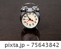 Metal alarm clock on a wooden table 75643842