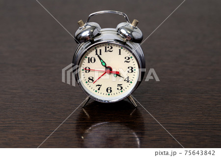 Metal alarm clock on a wooden table 75643842
