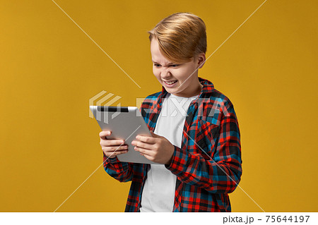 child boy in checkered shirt using digital tablet child boy in checkered shirt using digital tablet 75644197