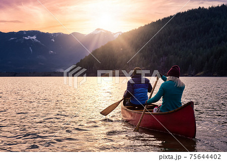 Couple friends canoeing on a wooden canoe 75644402
