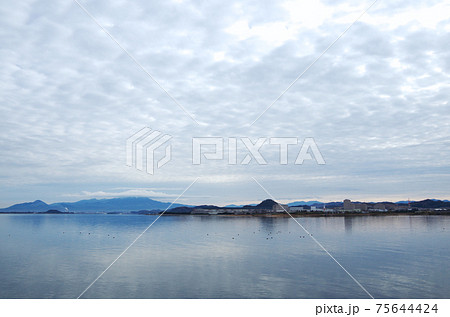 中海の岸から眺める大山の上空に大山を模写した形の雲が掛かっている風景 島根県 安来市 曇り の写真素材