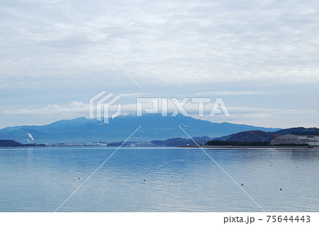中海の岸から眺める大山の上空に大山を模写した形の雲が掛かっている風景 島根県 安来市 曇り の写真素材