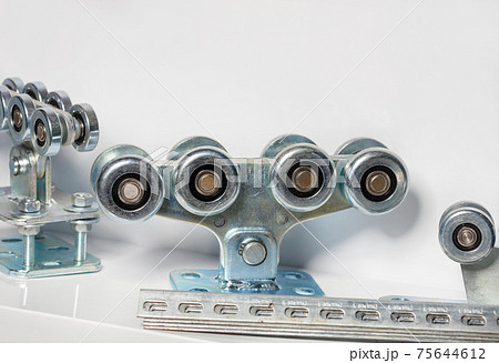 Powerful steel roller mechanisms for moving heavy loads on a gray background, close-up. 75644612