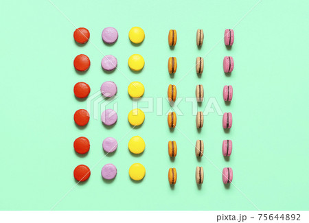 Multicolor macarons cookies with chocolate ganache filling, symmetric aligned. French cookies flat lay Multicolor macarons cookies with chocolate ganache filling, symmetric aligned. French cookies flat lay 75644892